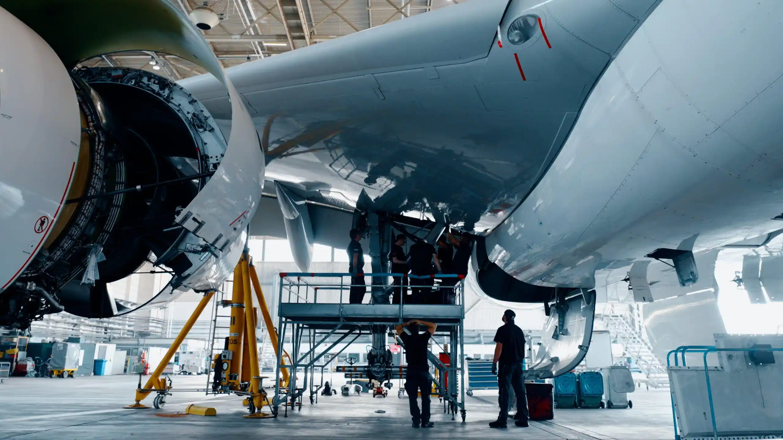 Commercial aircraft undergoing maintenance inside aerospace hangar