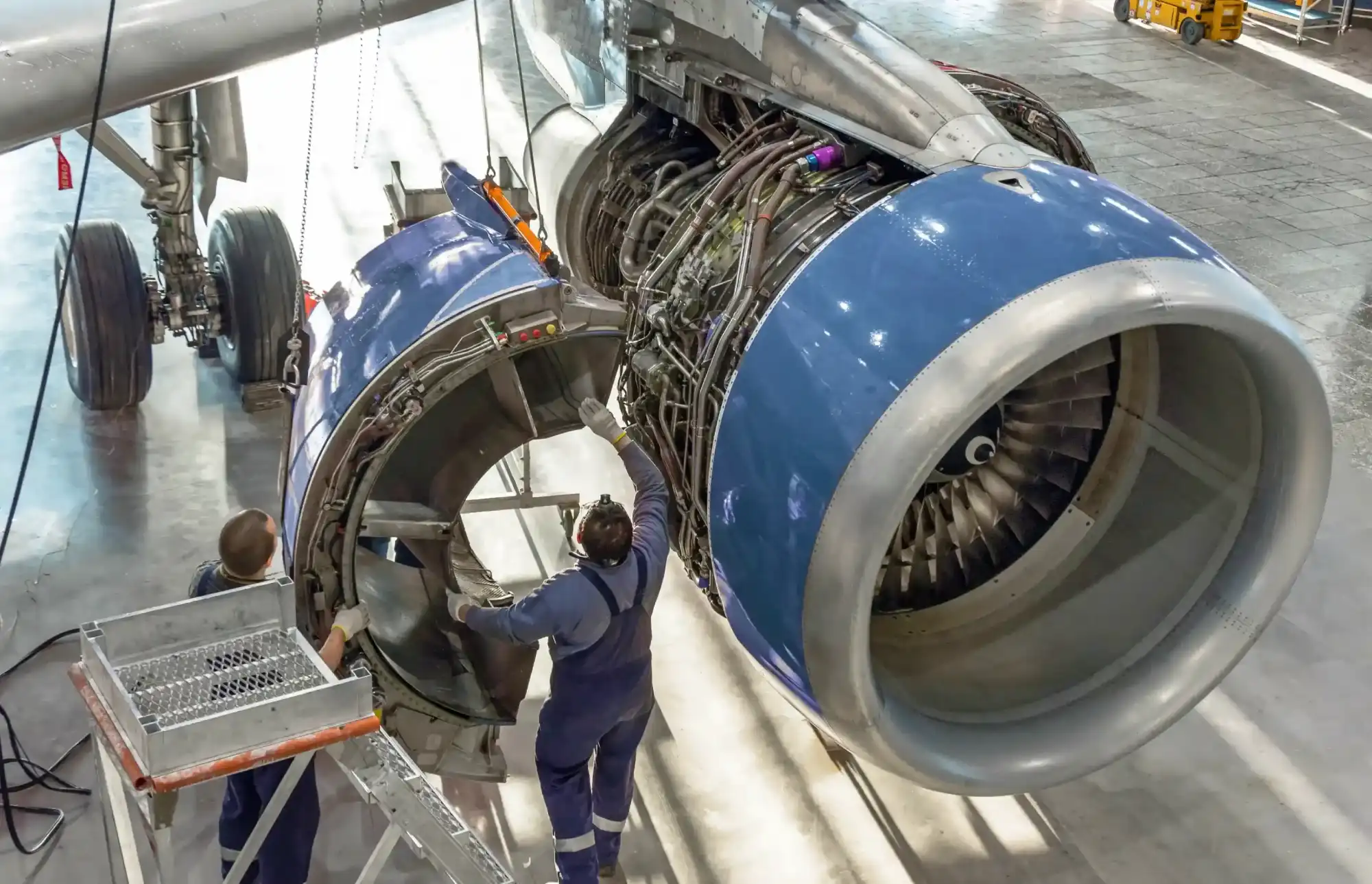Aircraft jet engine maintenance by aerospace engineers in aviation hangar