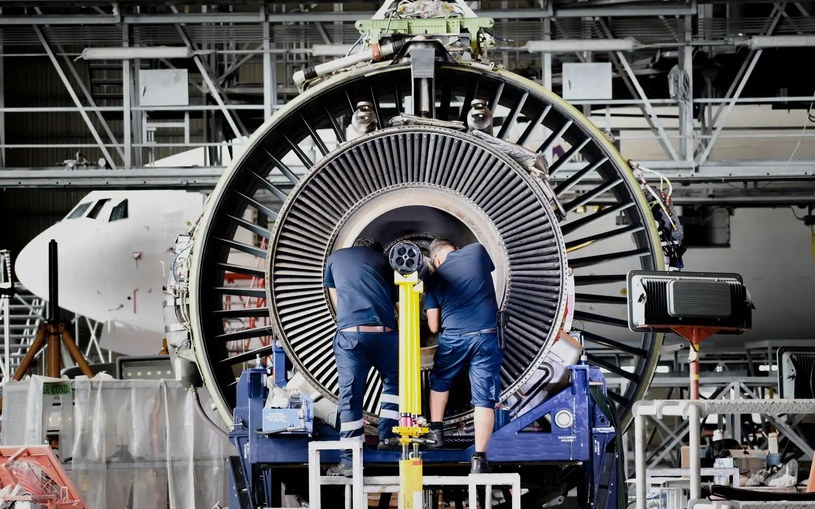 Aircraft turbine engine maintenance inside aerospace engineering facility
