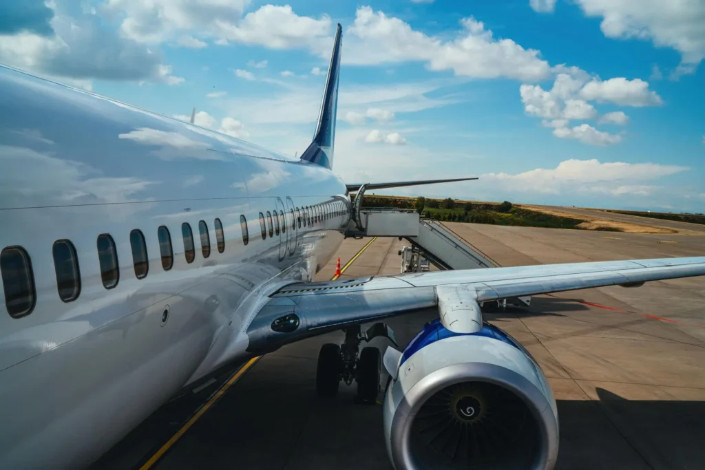 Commercial passenger aircraft parked on airport runway with visible jet engine